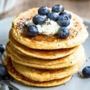 Stack of chia pancakes topped with yogurt, blueberries, and chia seeds