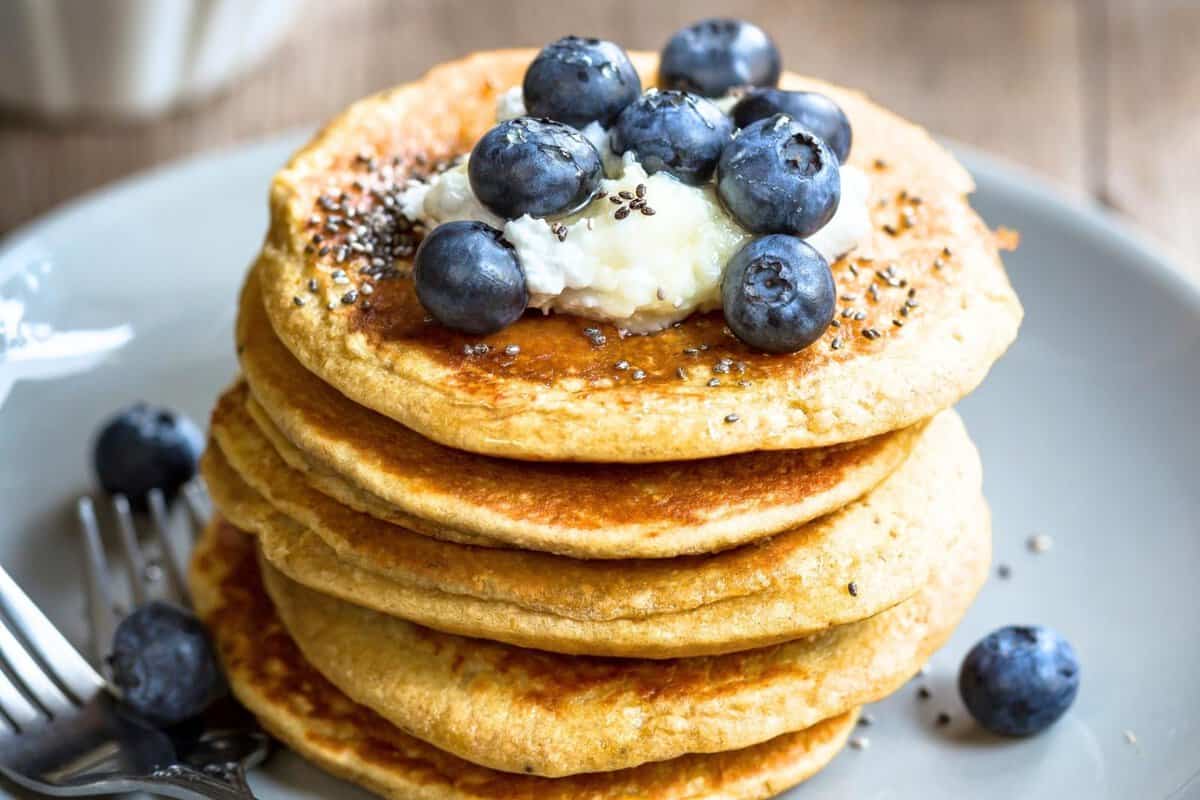 Stack of chia pancakes topped with yogurt, blueberries, and chia seeds