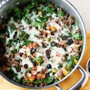overhead view of a ground beef and spinach skillet meal with cheese melted on top