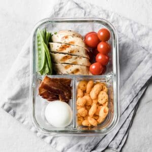 lunchobx with grilled chicken, bacon, hard boiled egg and veggies