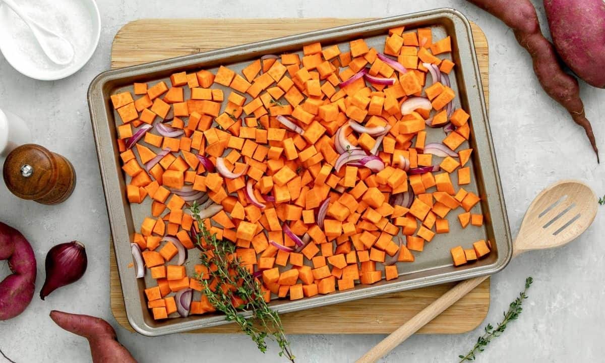 overhead view of sweet potato cubes on a sheet pan before baking