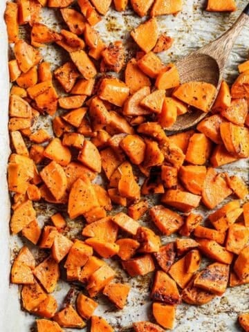 overhead view of roasted sweet potato cubes on a sheet pan