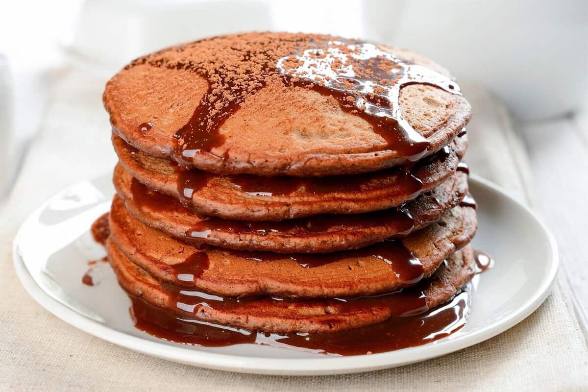 stack of chocolate pancakes made with pancake mix topped with chocolate syrup