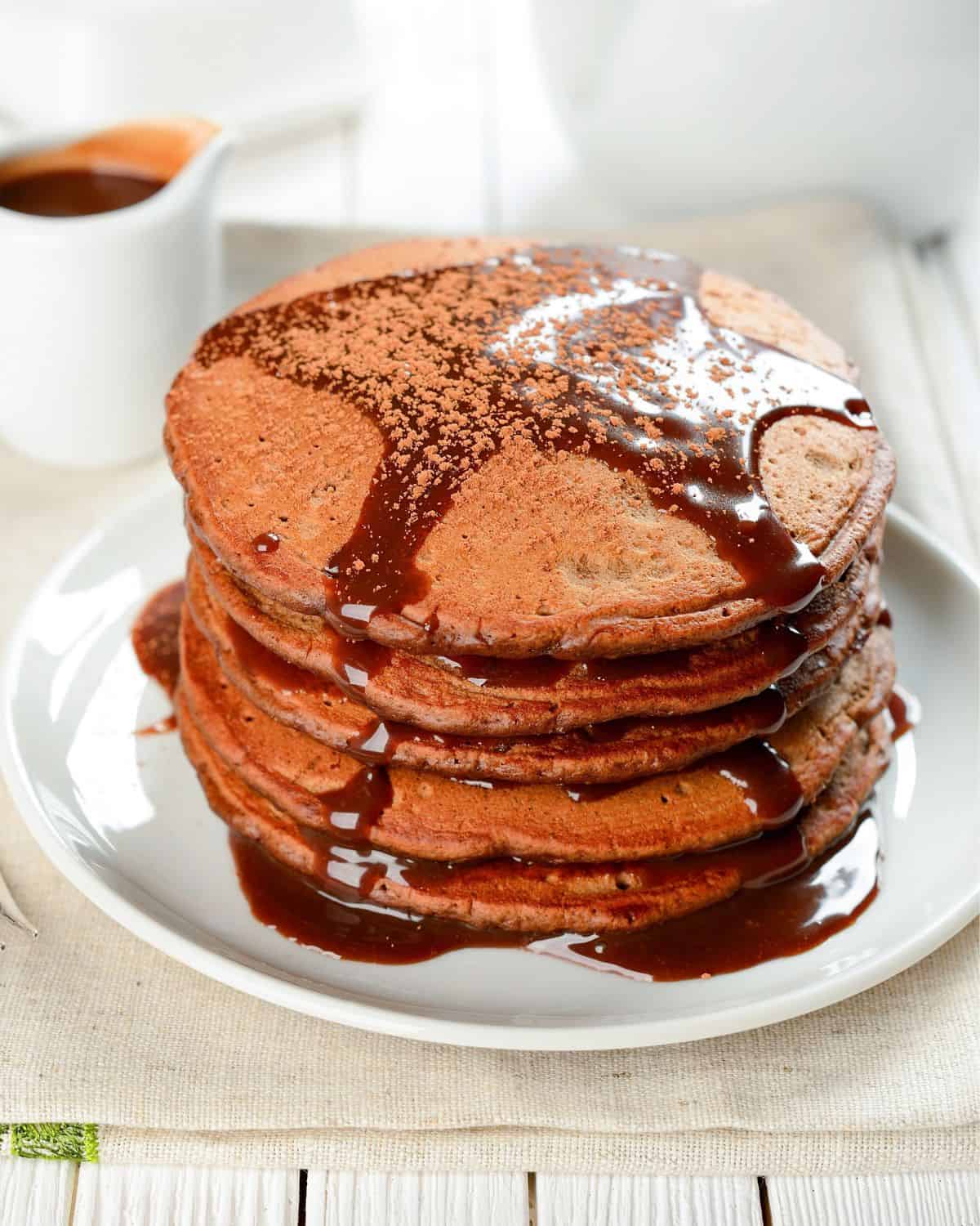 stack of chocolate pancakes made with pancake mix topped with chocolate syrup