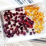 diced roasted beets and butternut squash in a foiled baking sheet