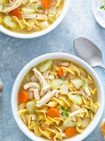 overhead view of two bowls of chicken noodle soup