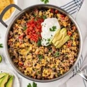 taco skillet with tortilla chips and avocado on the side
