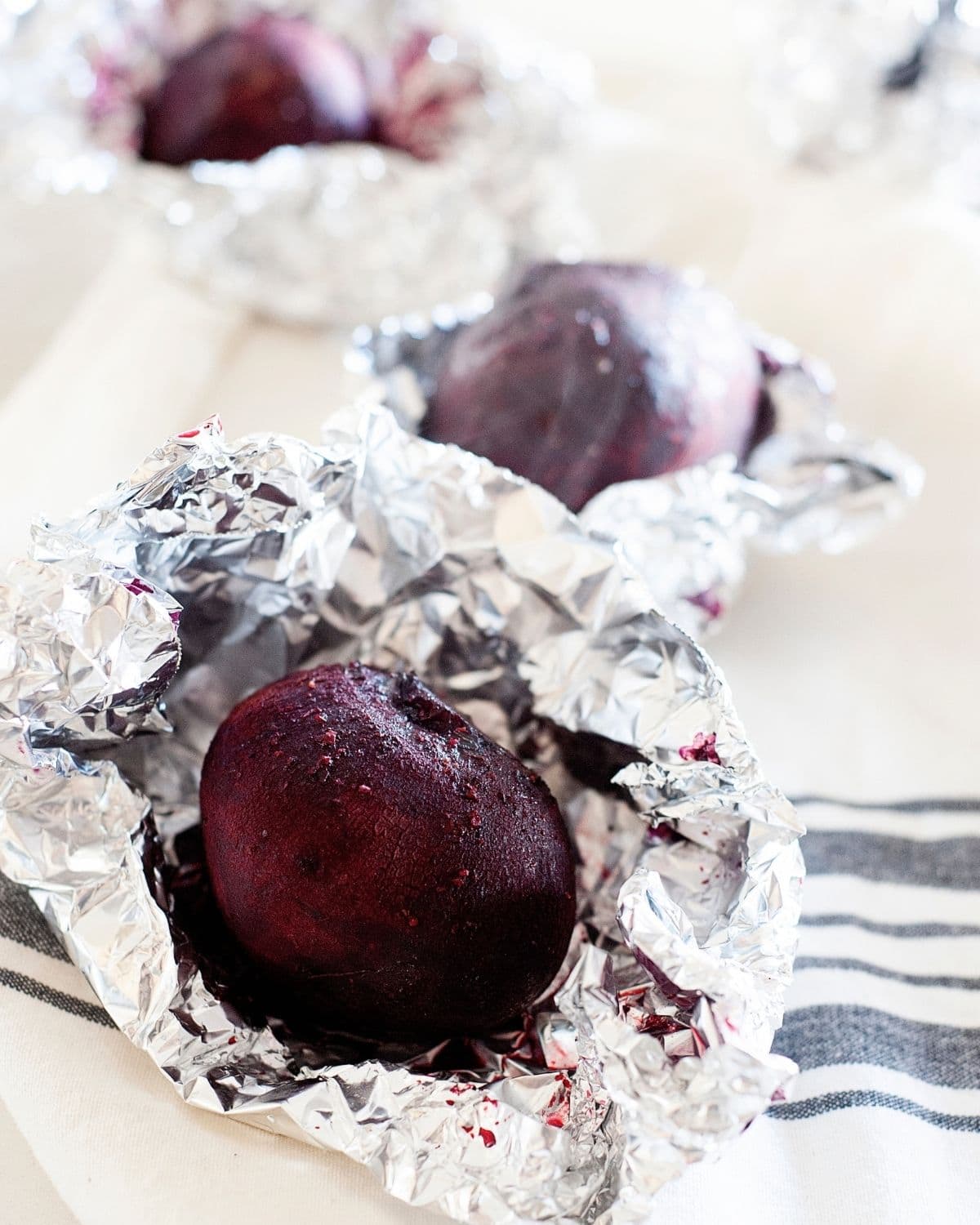 roasted whole beets cooling down on top of foil after roasting
