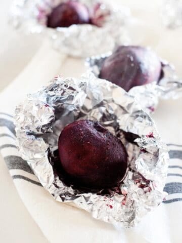 close up of a whole roasted beet inside foil