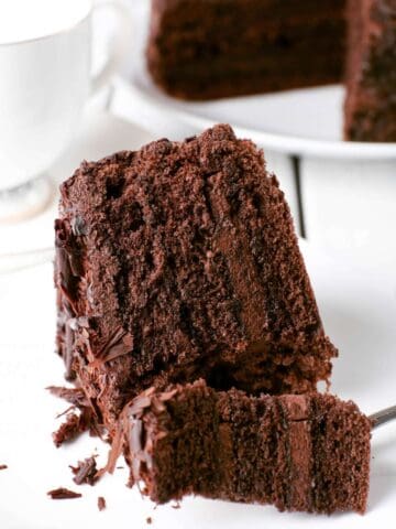 gluten free dairy free chocolate cake slice on a plate with a piece sliced on a fork