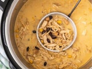 ladling out a serving of white chicken chili out of the instant pot