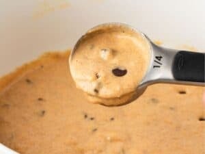 a spoon showing the consistency of pumpkin protein pancake batter