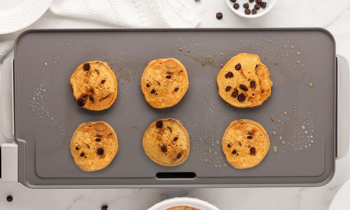 six pumpkin protein pancakes in a griddle