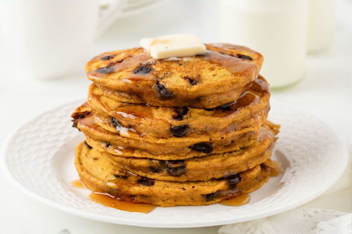 a stack of pumpkin protein pancakes topped with butter and syrup