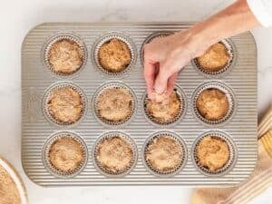 sprinkling brown sugar over sweet potato muffins in pan before baking