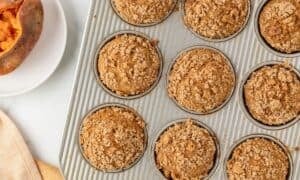 overhead view of sweet potato muffins in a baking pan after baking with a brown sugar topping