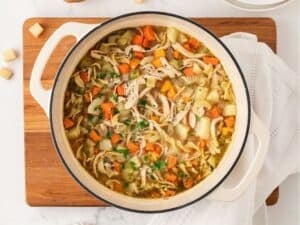 a pot of chicken noodle soup with potatoes