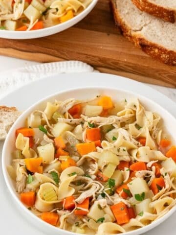 a bowl of chicken noodle soup with potatoes